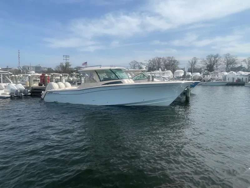 Slide: The Image of 2025 Grady-White Canyon 386 boat docked in a marina under a clear sky. - 9