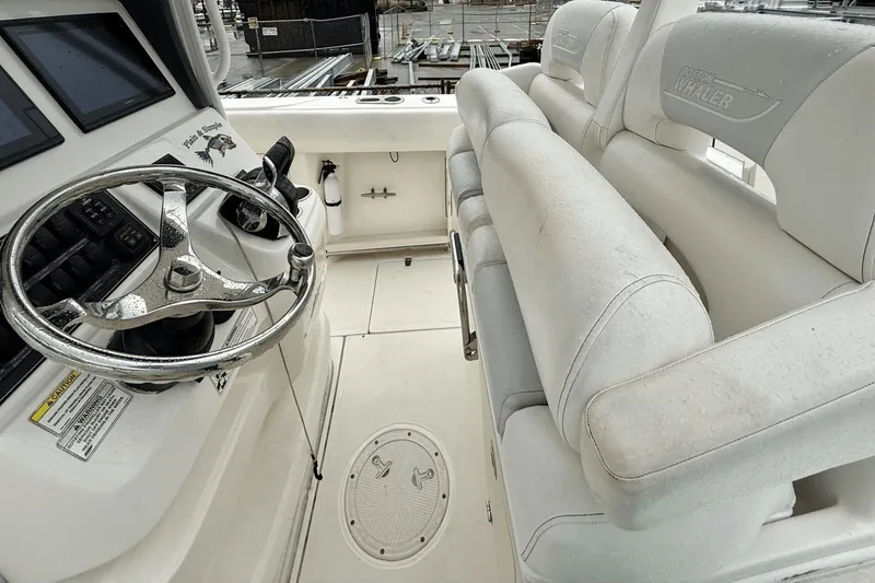Slide: The Image of 2015 Boston Whaler 280 Outrage helm with steering wheel and cushioned seating. - 10