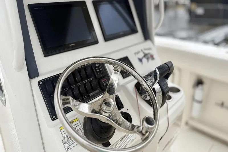 Slide: The Image of 2015 Boston Whaler 280 Outrage helm with steering wheel and navigation screens. - 12