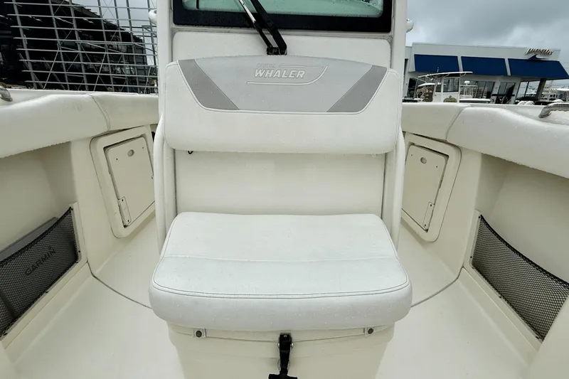 Slide: The Image of 2015 Boston Whaler 280 Outrage boat interior with cushioned seating and storage compartments. - 16