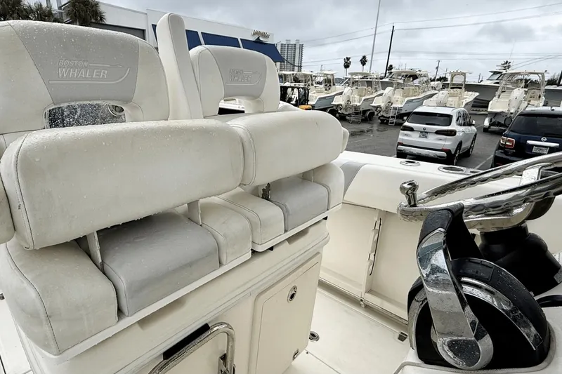 Slide: The Image of 2015 Boston Whaler 280 Outrage boat interior with white seating and steering wheel. - 18