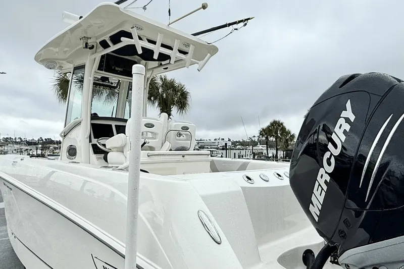 Slide: The Image of 2015 Boston Whaler 280 Outrage boat with Mercury engine, docked under cloudy skies. - 7