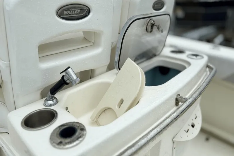Slide: The Image of 2015 Boston Whaler 280 Outrage boat sink and storage area, featuring faucet and compartments. - 9
