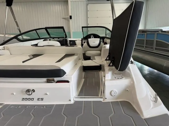 Slide: The Image of 2023 Regal 2000 ES boat interior with seating and steering wheel in a showroom. - 8