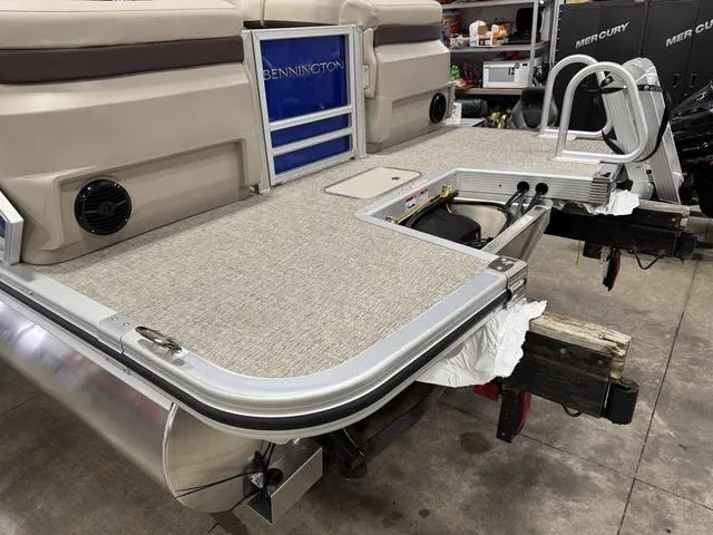 Slide: The Image of 2025 Bennington M Quad Bench 24 MFB pontoon boat rear view in a workshop. - 21