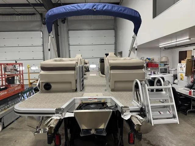 Slide: The Image of 2025 Bennington M Quad Bench 24 MFB pontoon boat in a garage setting. - 4