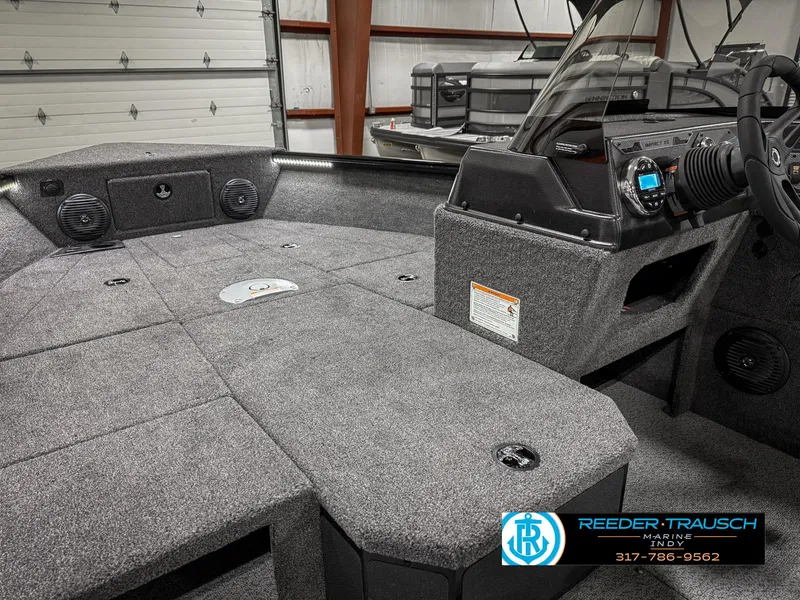 Slide: The Image of 2025 Lund 1775 IMPACT XS boat interior with gray carpet and dashboard controls. - 28