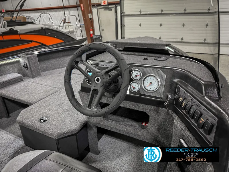 Slide: The Image of 2025 Lund 1775 IMPACT XS SINGLE boat interior with steering wheel and dashboard controls. - 34