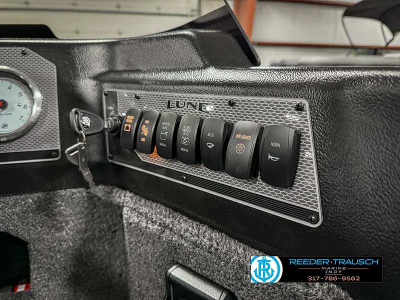 Slide: The Image of Control panel of 2025 Lund 1775 IMPACT XS SINGLE boat with various switches and key ignition. - 38