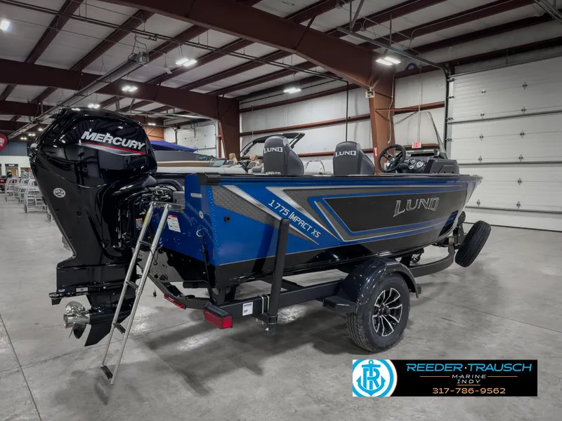 Slide: The Image of 2025 Lund 1775 Impact XS Single boat in showroom, featuring Mercury engine and trailer. - 6