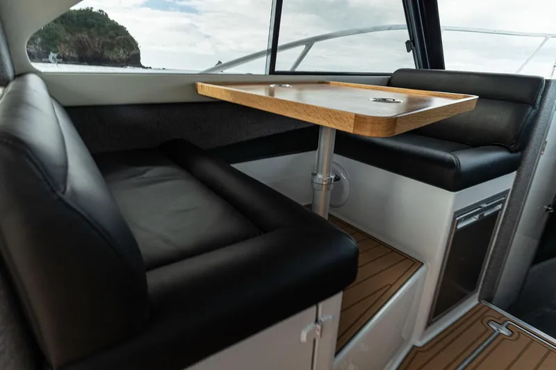 Slide: The Image of Interior of 2025 Makaira Gen3 1000 boat with sleek seating and wooden table. - 10