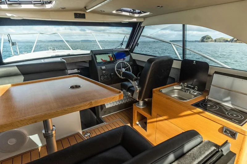 Slide: The Image of Interior of 2025 Makaira Gen3 1000 yacht with helm, table, and kitchenette. - 5
