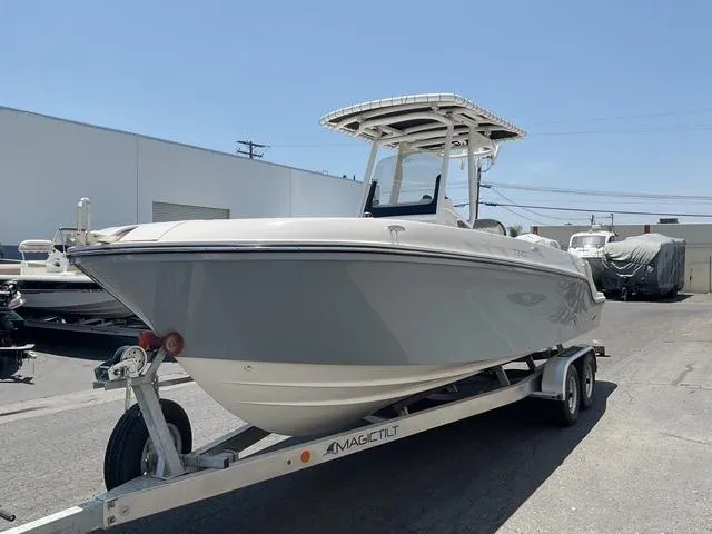 Slide: The Image of 2025 Bayliner Trophy T24CC boat on trailer, parked outdoors under clear sky. - 4