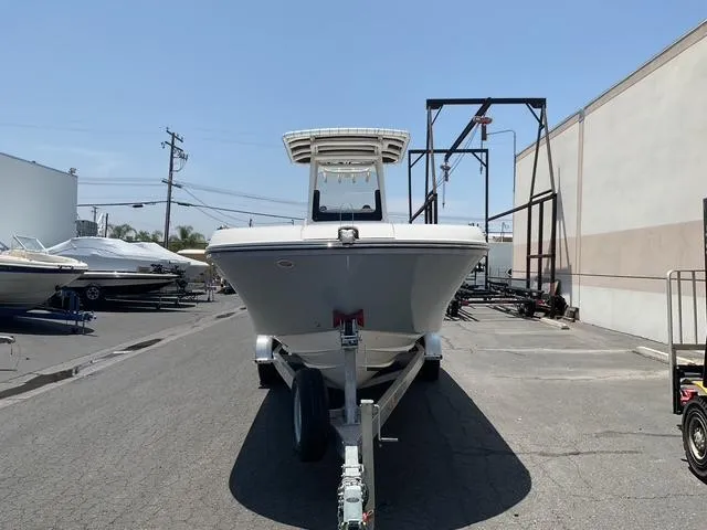 Slide: The Image of 2025 Bayliner Trophy T24CC boat on trailer in marina parking lot. - 5