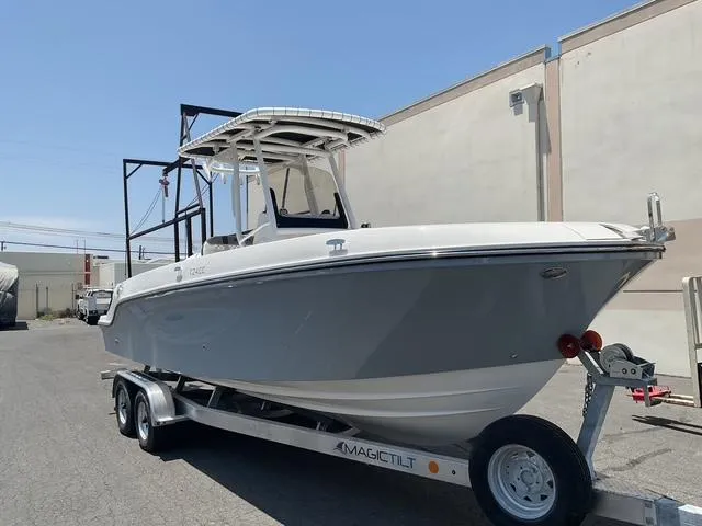 Slide: The Image of 2025 Bayliner Trophy T24CC boat on trailer, parked outdoors. - 6