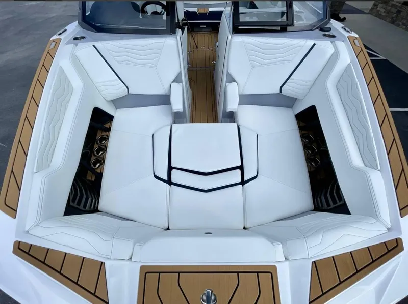 Slide: The Image of 2025 Nautique G23 boat interior with white cushioned seating and wood accents. - 16