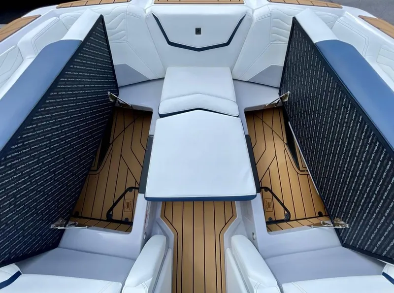 Slide: The Image of 2025 Nautique G23 boat interior with white seating and teak flooring. - 18