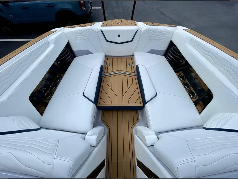 Slide: The Image of 2025 Nautique G23 boat interior with white seating and wood accents. - 19