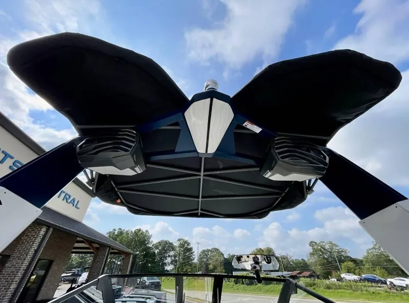 Slide: The Image of 2025 Nautique G23 boat with speakers and canopy, viewed from below against a blue sky. - 20