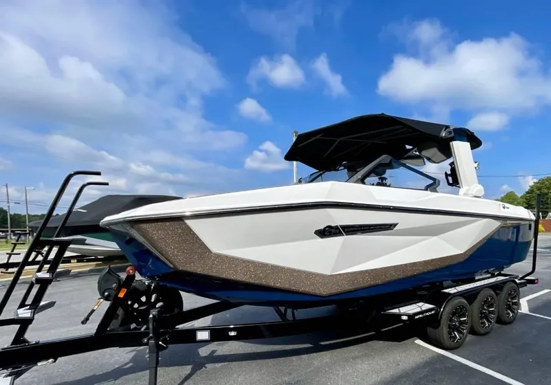 Slide: The Image of 2025 Nautique G23 boat on trailer under blue sky. - 3