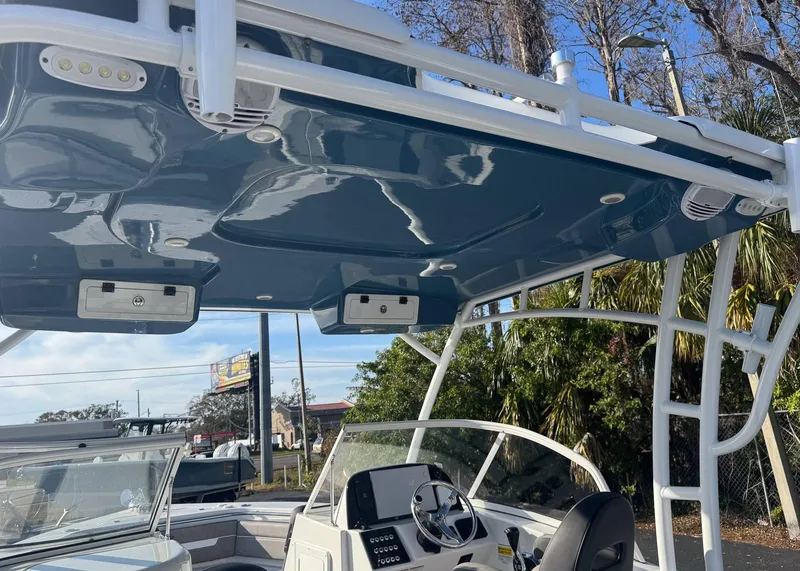 Slide: The Image of 2023 Sea Pro 240 DC boat with sleek blue hardtop and modern helm design. - 14