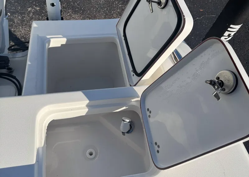 Slide: The Image of 2023 Sea Pro 240 DC boat storage compartments with open lids. - 7