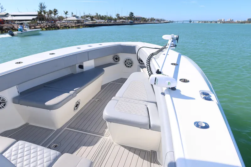 Slide: The Image of 2020 SeaVee 370z boat with spacious seating, docked in a serene marina setting. - 10