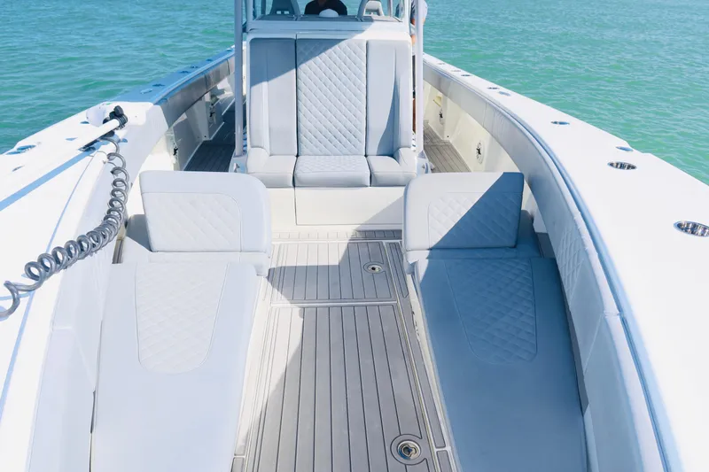 Slide: The Image of 2020 SeaVee 370z boat interior with cushioned seating and teak flooring on calm water. - 11