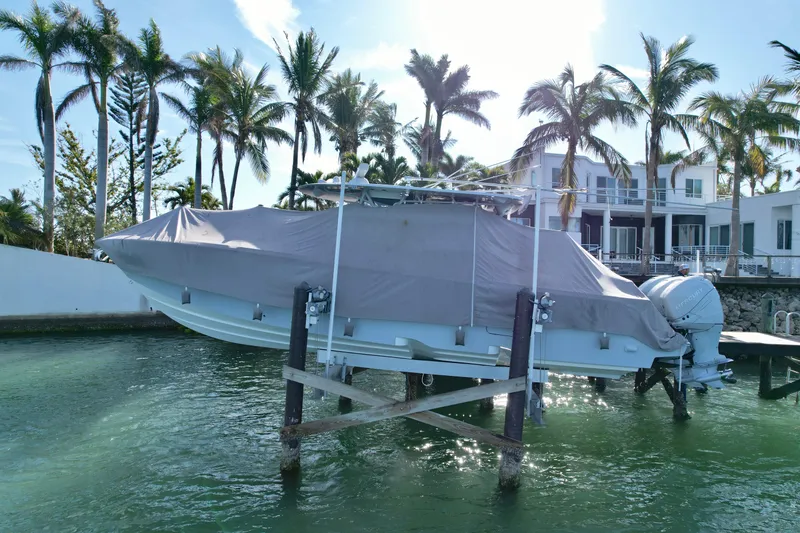 Slide: The Image of 2020 SeaVee 370z boat covered and docked near waterfront homes and palm trees. - 3
