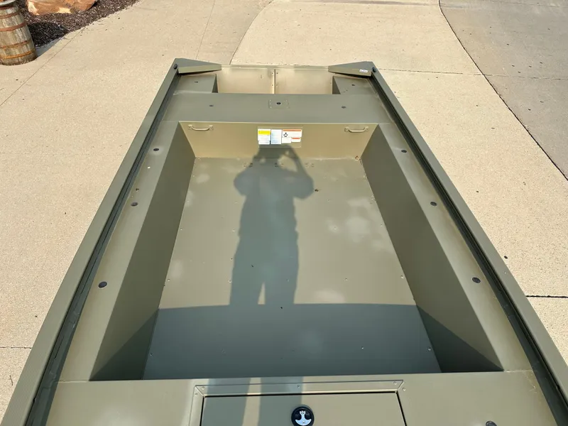 Slide: The Image of 2025 Tracker Grizzly 1754 Jon boat, empty interior view, shadow on deck. - 2