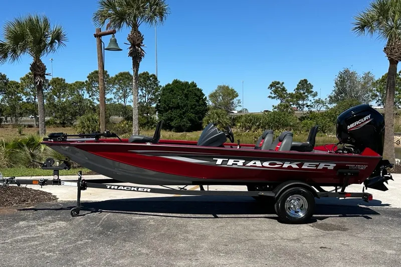 The Image of 2025 Tracker Pro Team 175 boat on trailer, parked outdoors with trees in background. - 0