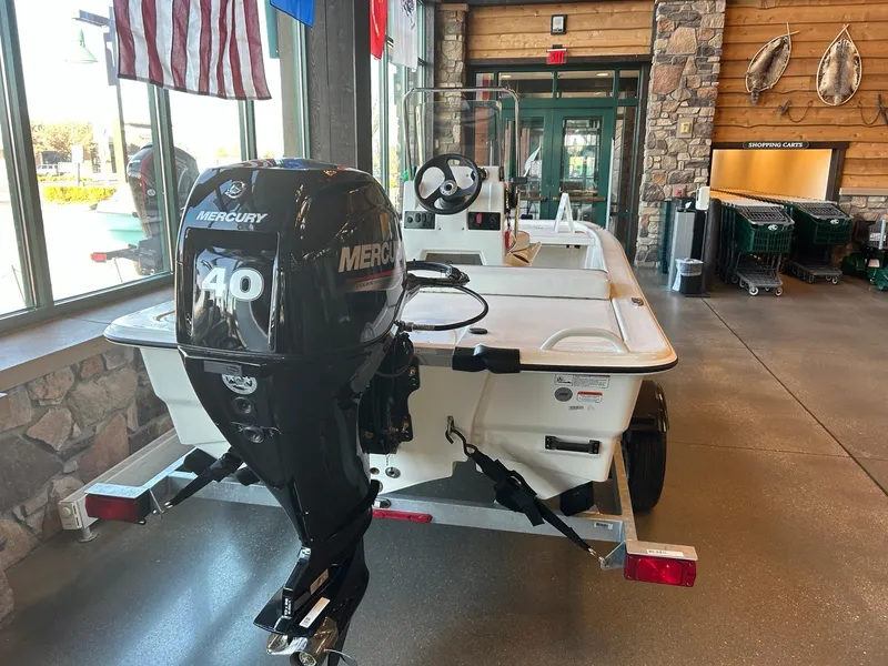 Slide: The Image of 2025 Mako Pro Skiff 13 CC with Mercury 40 engine displayed indoors. - 1