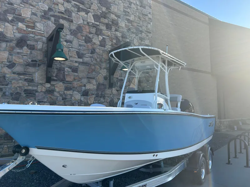 Slide: The Image of 2025 Mako 214 CC boat in blue, displayed outdoors on a trailer. - 1