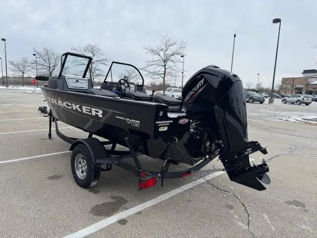 Slide: The Image of 2025 Tracker Pro Guide V-16 WT boat with Mercury engine in a parking lot. - 4