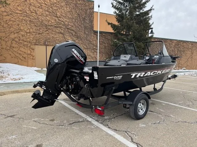 Slide: The Image of 2025 Tracker Pro Guide V-16 WT boat with Mercury engine in parking lot. - 5
