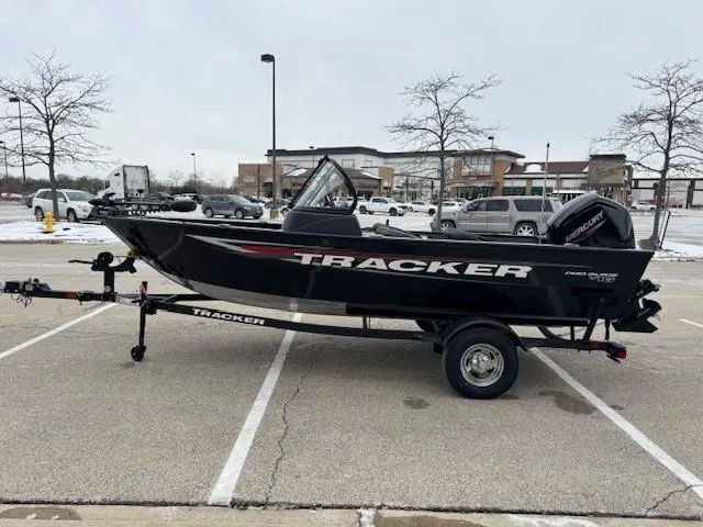 Slide: The Image of 2025 Tracker Pro Guide V-16 WT boat on trailer in parking lot. - 6