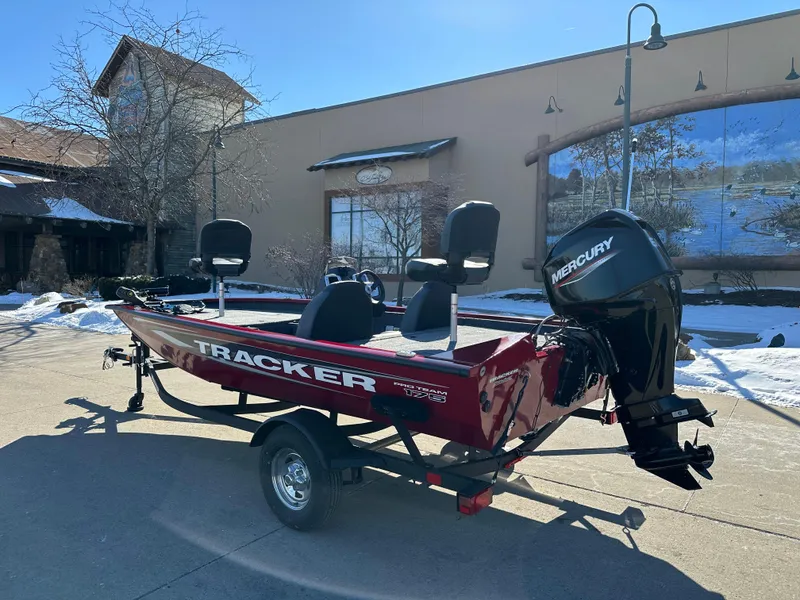 Slide: The Image of 2025 Tracker Pro Team 175 boat with Mercury engine, parked outdoors. - 2