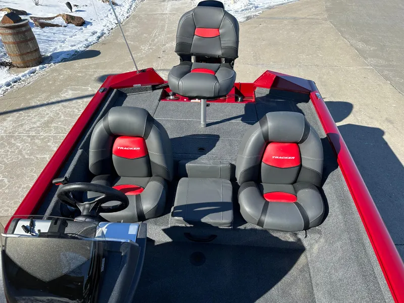 Slide: The Image of 2025 Tracker Pro Team 175 boat with red and black seating on a sunny day. - 6