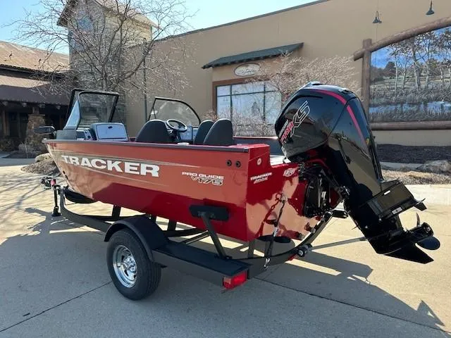 Slide: The Image of 2025 Tracker Pro Guide V-175 WT boat with outboard motor, parked outdoors. - 2