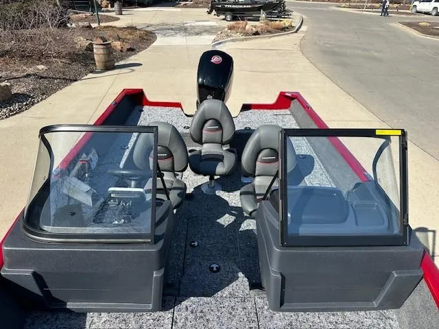 Slide: The Image of 2025 Tracker Pro Guide V-175 WT boat with seating and windshield, parked on pavement. - 6