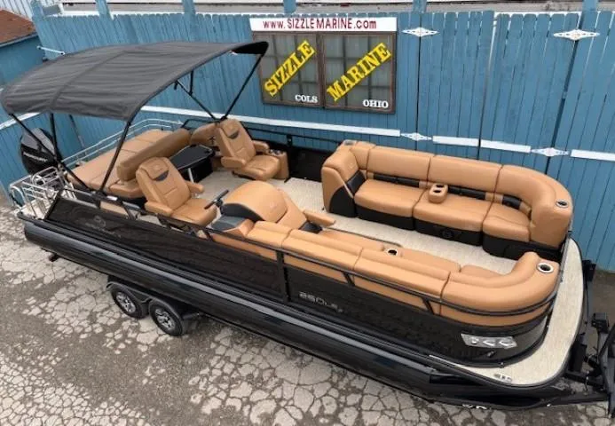 Slide: The Image of 2024 Regency 250 LE3 Sport pontoon boat with tan seating and black canopy. - 0
