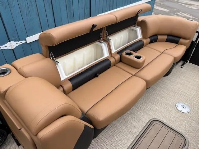 Slide: The Image of 2024 Regency 250 LE3 Sport boat seating with tan upholstery and built-in cup holders. - 13