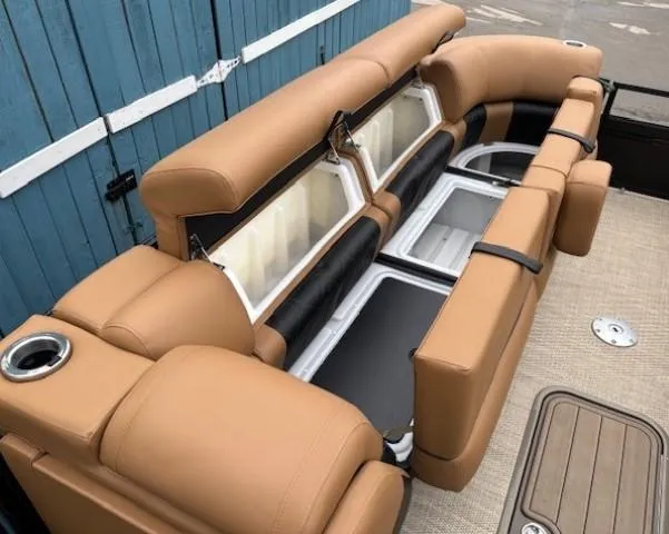 Slide: The Image of 2024 Regency 250 LE3 Sport boat seating with storage compartments, tan upholstery, and cup holders. - 14