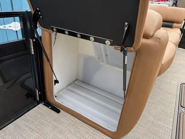 Slide: The Image of 2024 Regency 250 LE3 Sport storage compartment with tan upholstery and hydraulic hinges. - 16