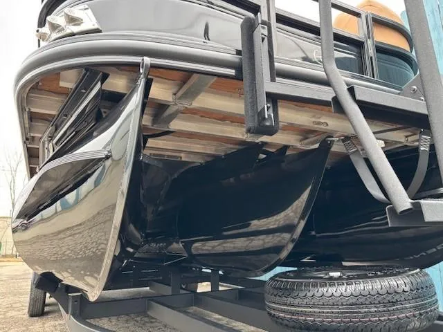 Slide: The Image of 2024 Regency 250 LE3 Sport pontoon boat undercarriage view with sleek black pontoons. - 3