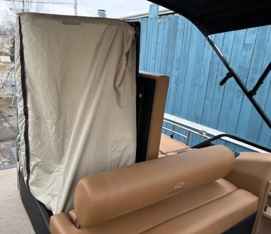 Slide: The Image of 2024 Regency 250 LE3 Sport boat interior with tan seating and covered area. - 31