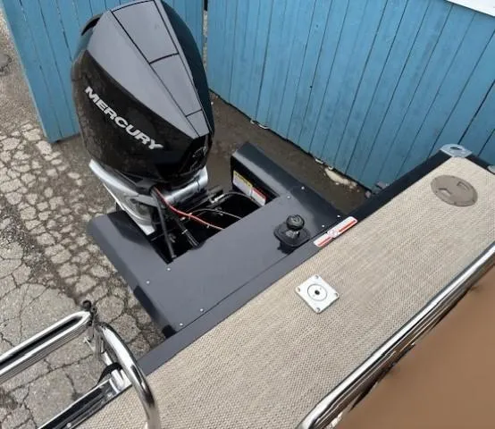 Slide: The Image of 2024 Regency 250 LE3 Sport boat with Mercury outboard motor, docked near blue fence. - 33