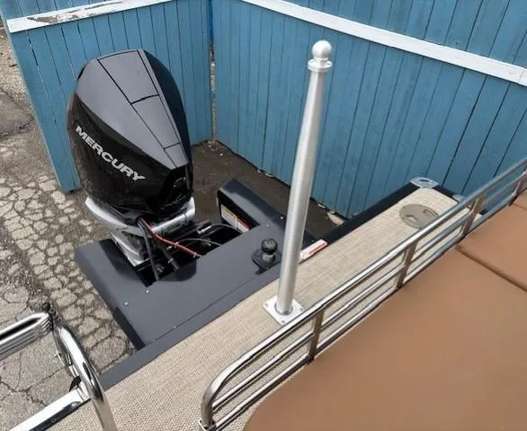 Slide: The Image of 2024 Regency 250 LE3 Sport boat with Mercury outboard motor, docked near blue fence. - 34