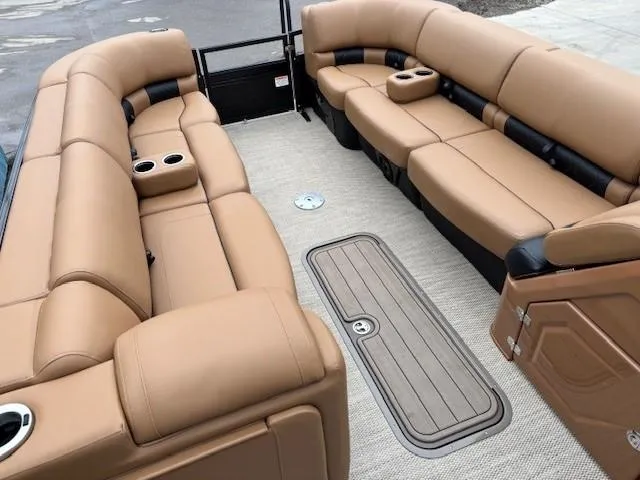 Slide: The Image of 2024 Regency 250 LE3 Sport pontoon boat interior with tan leather seating and cup holders. - 8