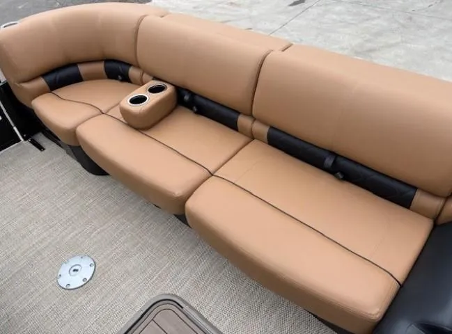 Slide: The Image of 2024 Regency 250 LE3 Sport boat seating, tan upholstery with cup holders, on a textured deck. - 9
